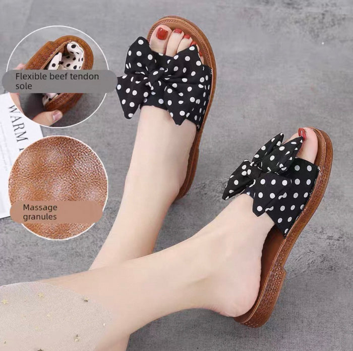 Black polka dot sandals with massage granules on a gray surface