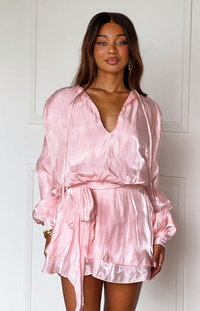 Front view of a pink crinkled satin mini dress featuring a deep V-neck, long cuffed sleeves, and a self-tie waist