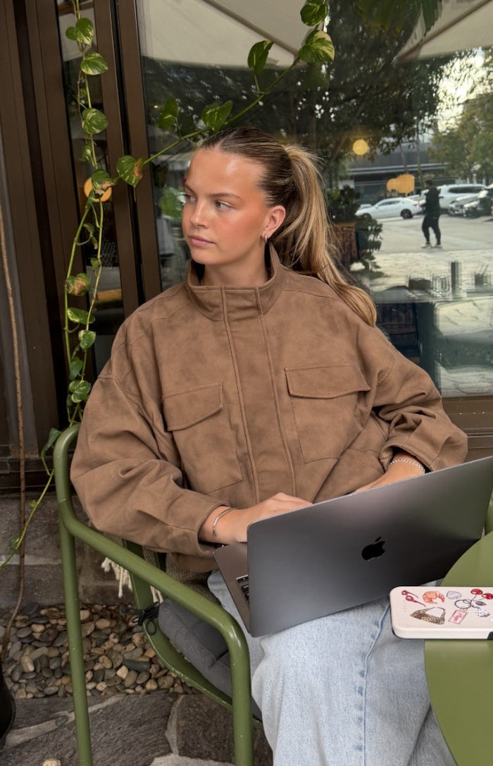 Brown oversized suedette jacket with a funnel neck, long sleeves, and two large chest flap pockets