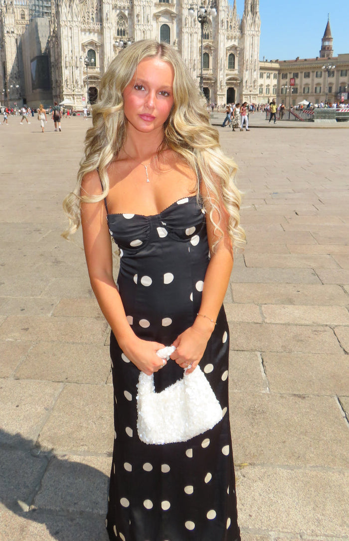 Front view of a black satin polka dot maxi dress with a sweetheart neckline and thin spaghetti straps