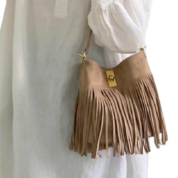Beige suede-look microfiber crossbody bucket bag with relaxed fringed silhouette worn with a white blouse
