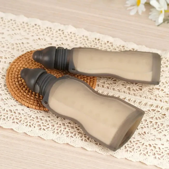Two soft gray silicone baby bottles from Toshi Baby Romper collection for easy feeding