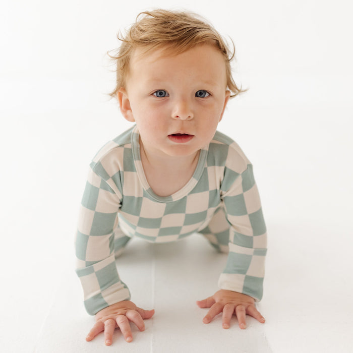 Baby wearing a checkered outfit on a white background