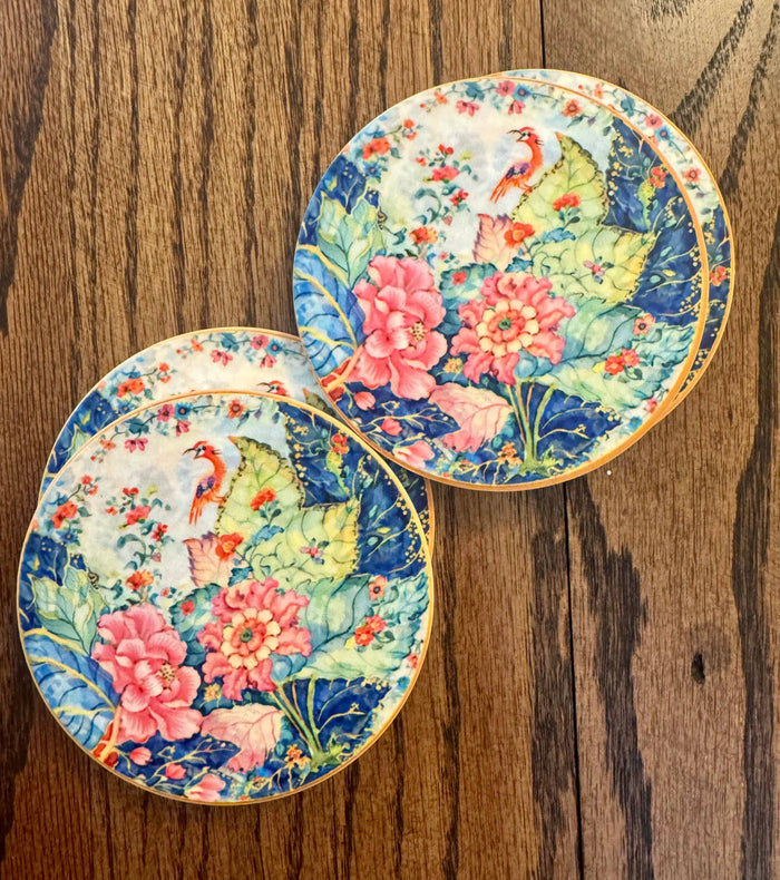 Set of two Tobacco Leaf-inspired ceramic coasters with colorful floral and bird design and natural cork backing
