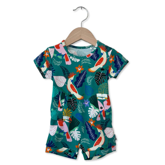 Children's outfit with tropical bird and leaf pattern on a hanger against a white background