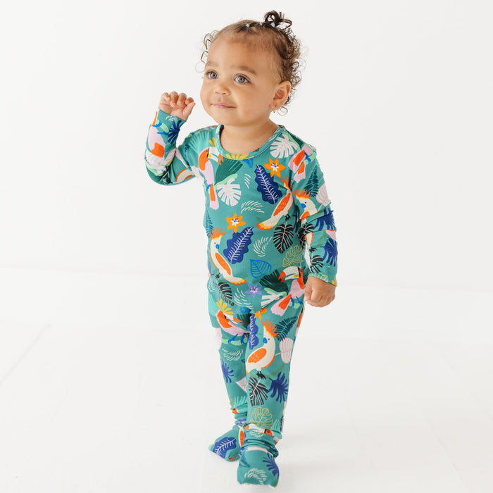 Baby wearing a colorful onesie with a floral pattern on a white background