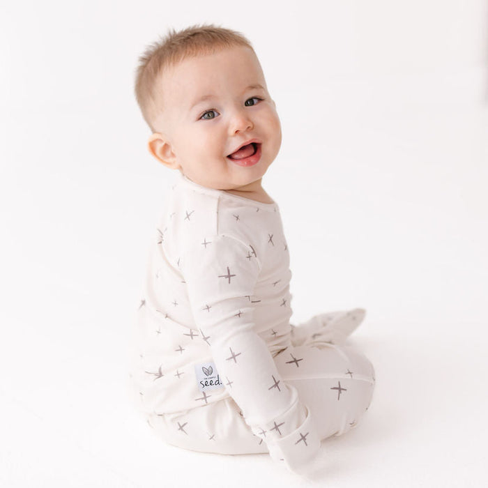 Baby wearing a white onesie with star patterns on a white background