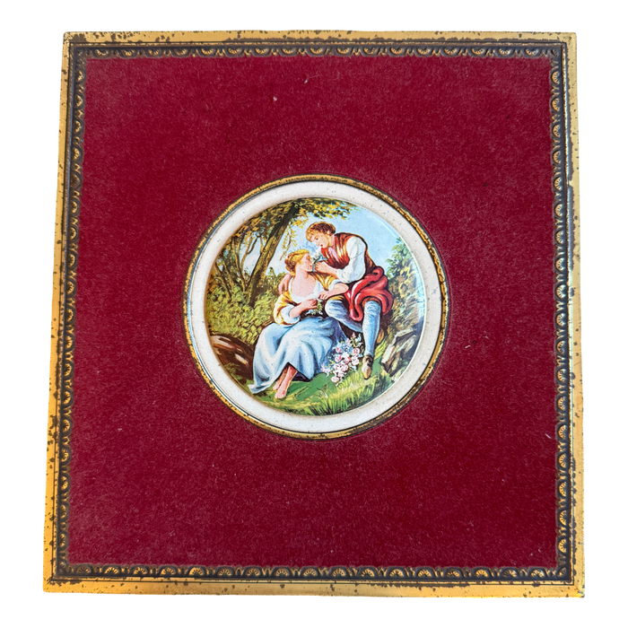 Decorative box with a circular painting of a couple on a red background