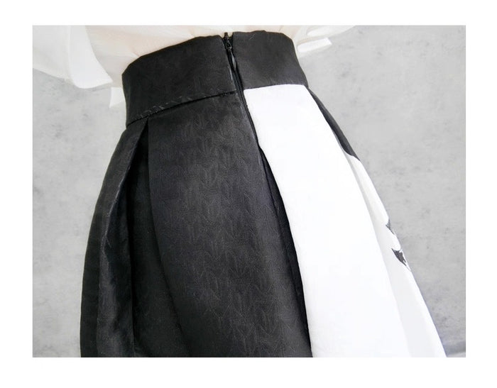 Black and white dress with a zipper detail on a gray background