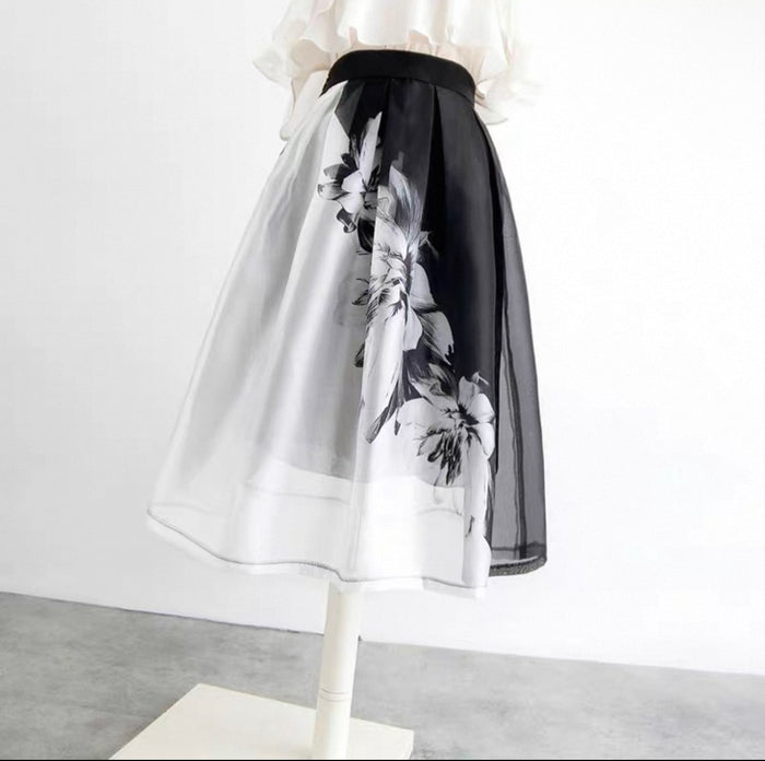 Skirt with black floral pattern on a mannequin against a white background