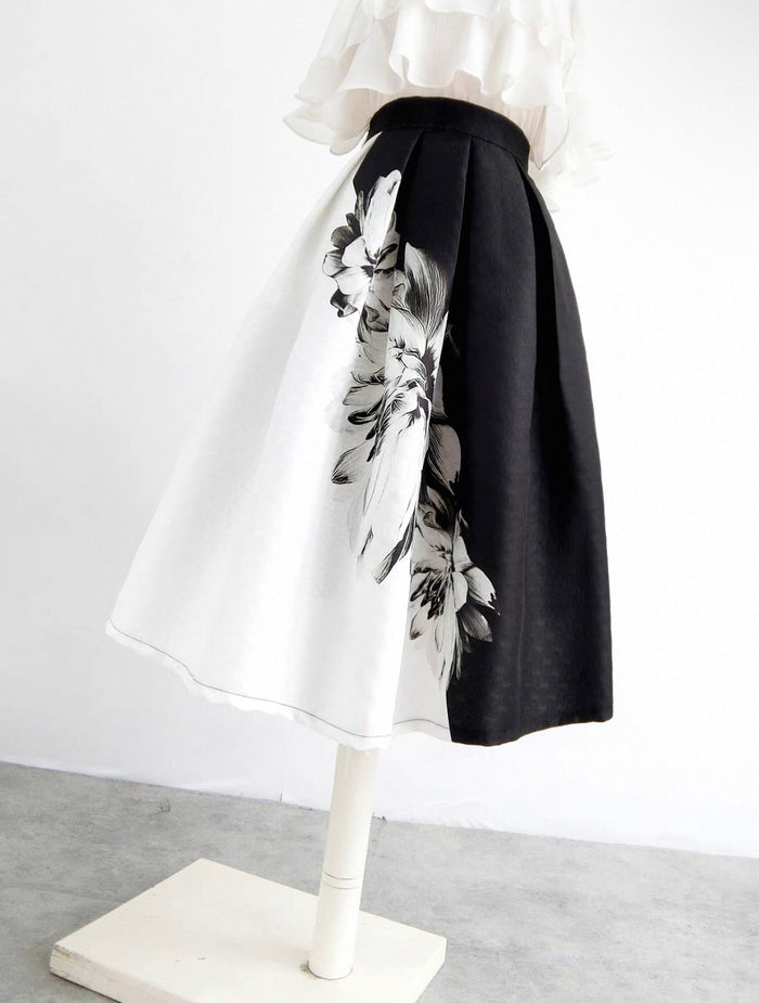 Mannequin wearing a black and white floral skirt with a plain background