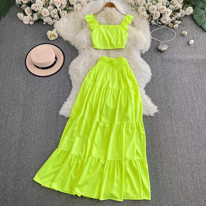 Neon green dress with matching top on a textured surface with flowers and a hat.