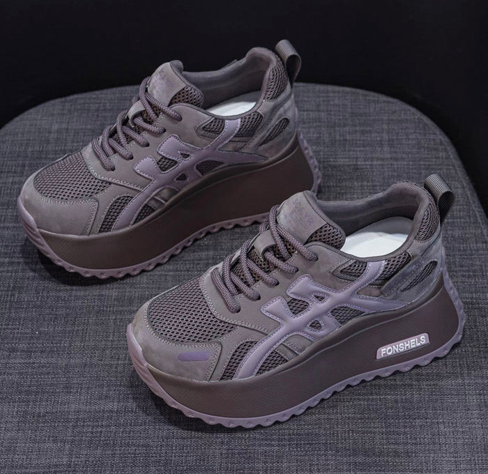 Gray sneakers with a brand logo on a textured surface