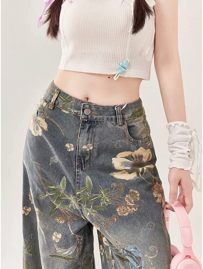 Person wearing floral-patterned jeans with a white top on a plain background