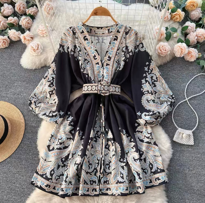 Black dress with white lace patterns on a hanger against a floral and textured background