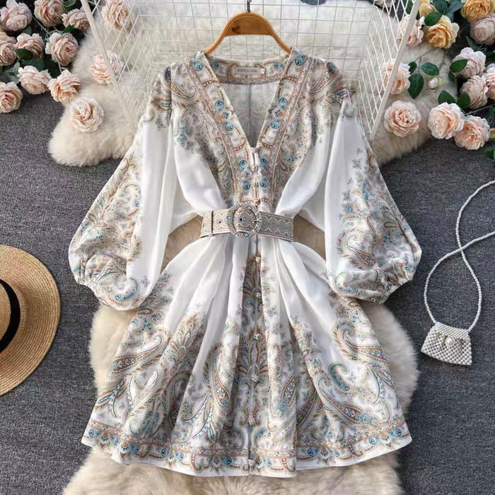 Floral dress with long sleeves on a hanger against a decorative background with flowers and a bag.