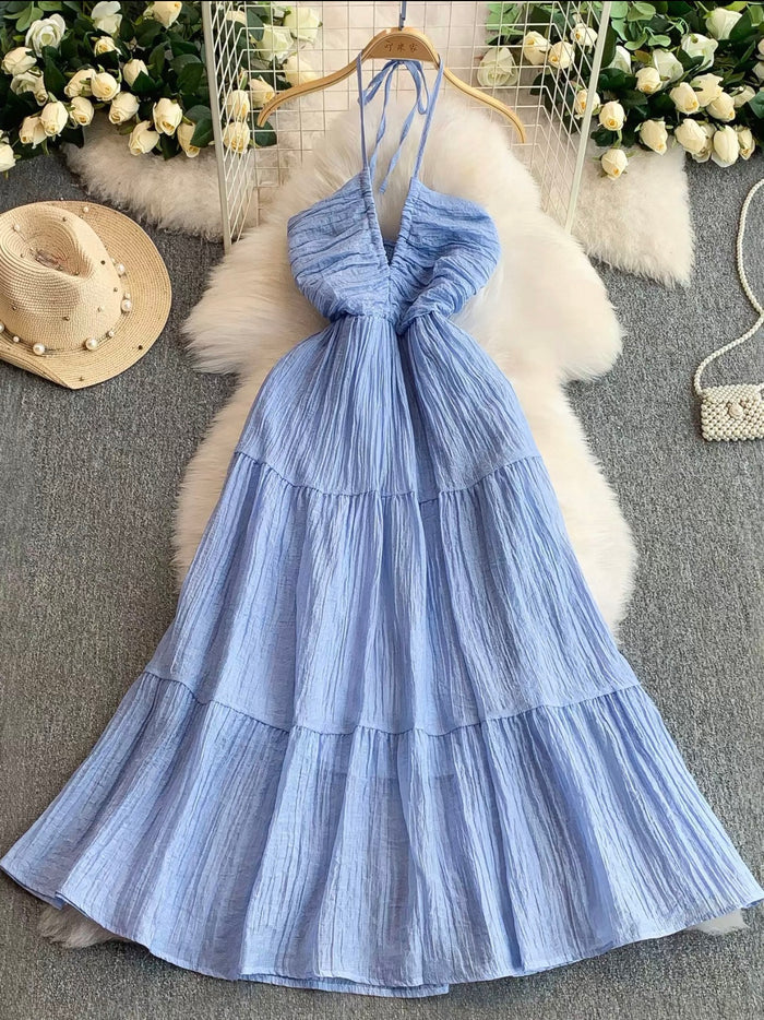 Blue dress on a hanger with floral decorations in the background