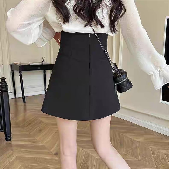 Person wearing a white blouse and black skirt in an indoor setting