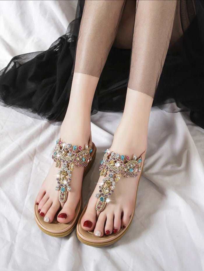 Elegant sandals with gemstone embellishments on a white surface