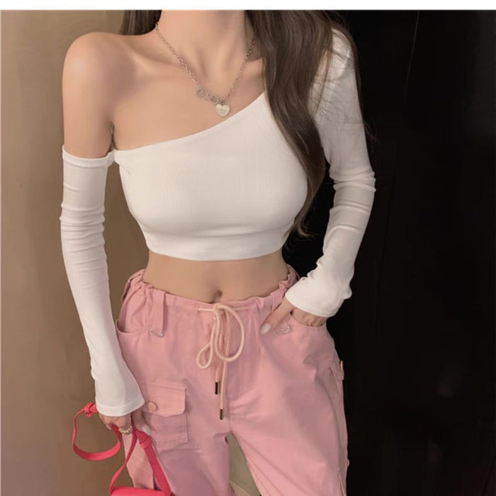 Person wearing a white off-shoulder top and pink pants with a plain background