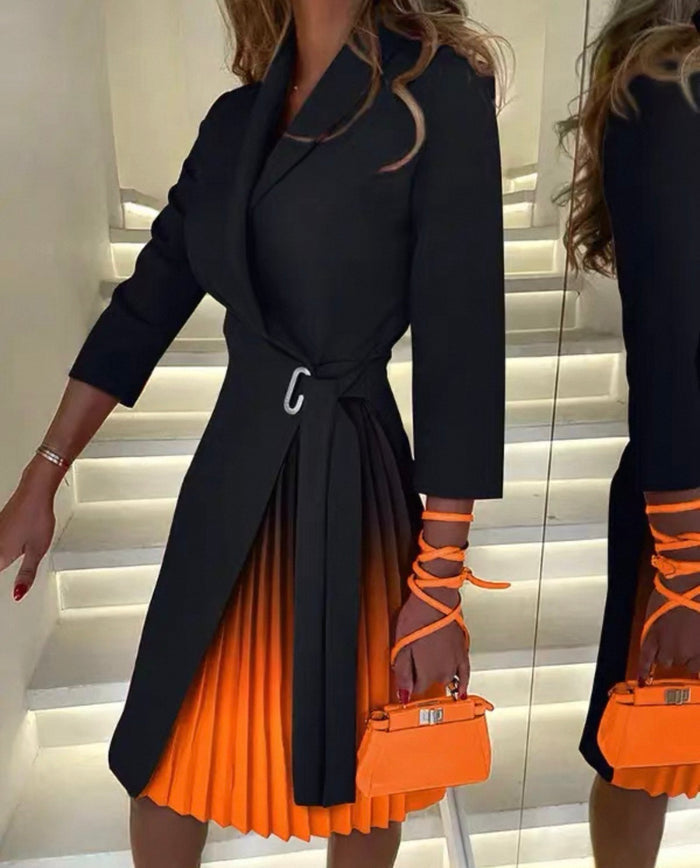 Person wearing a black coat and orange pleated skirt holding an orange handbag.