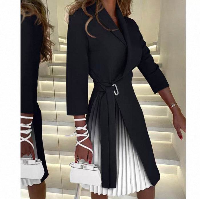 Woman wearing a black coat over a white dress with white shoes in a mirror reflection.
