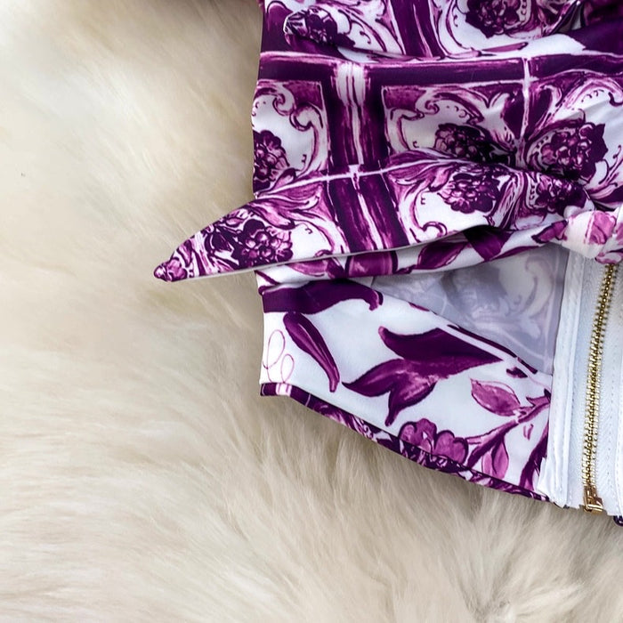 Purple and white patterned fabric on a fluffy beige surface