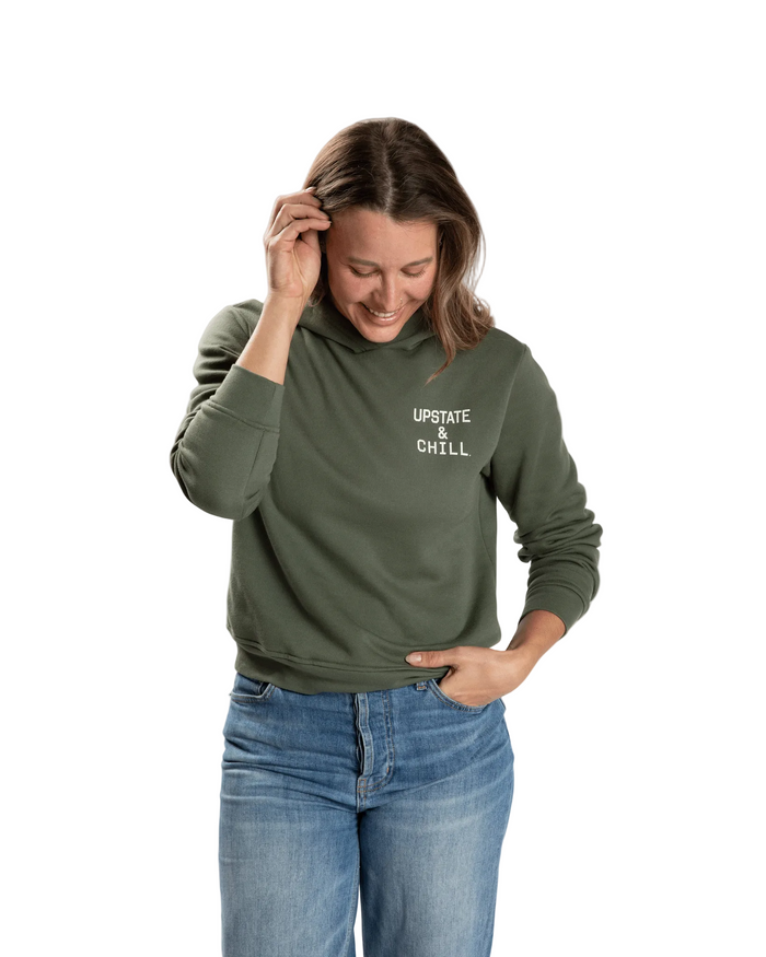 Woman wearing a green hoodie with 'Upstate & Chill' text on a white background