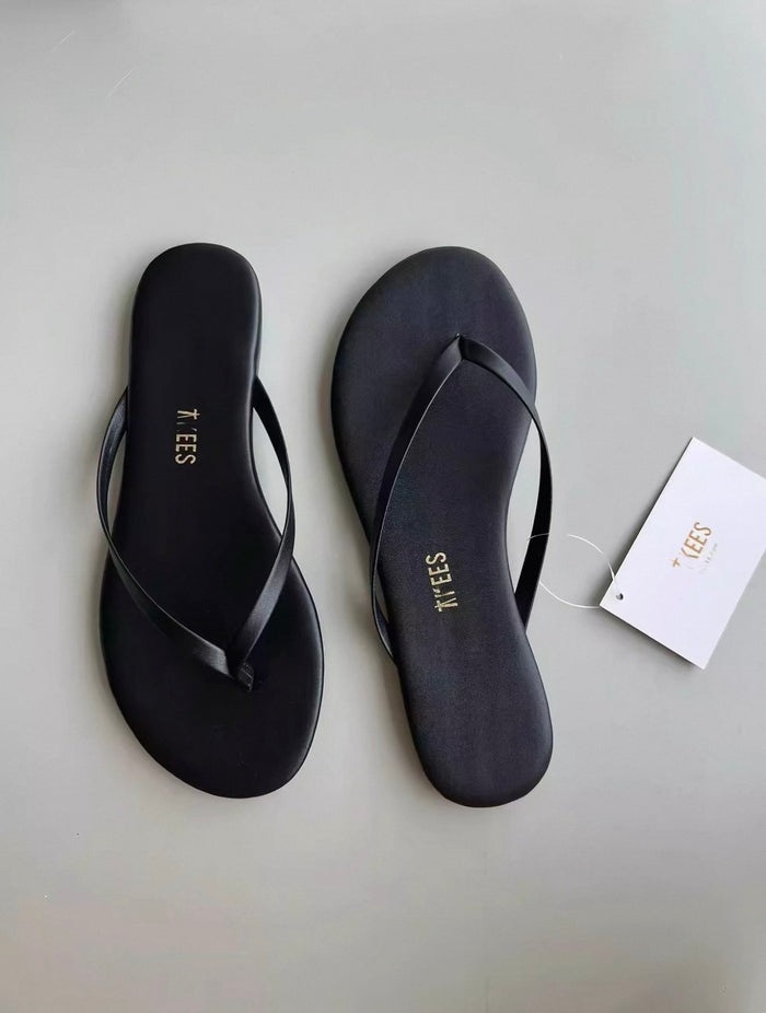 Black sandals with 'XUES' branding on a light gray background