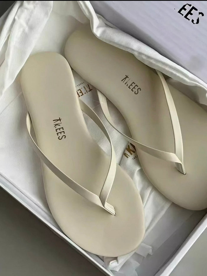 Pair of beige flip-flops with 'KLEES' branding in a white box.