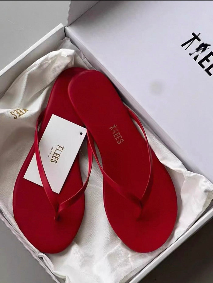 Red flip-flops with a visible brand tag in an open box.