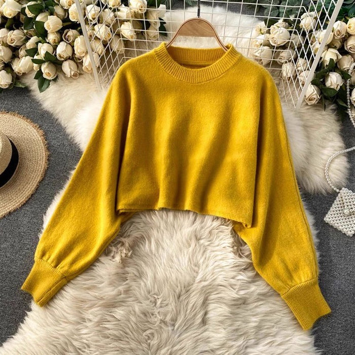 Yellow sweater on a hanger with floral decorations in the background