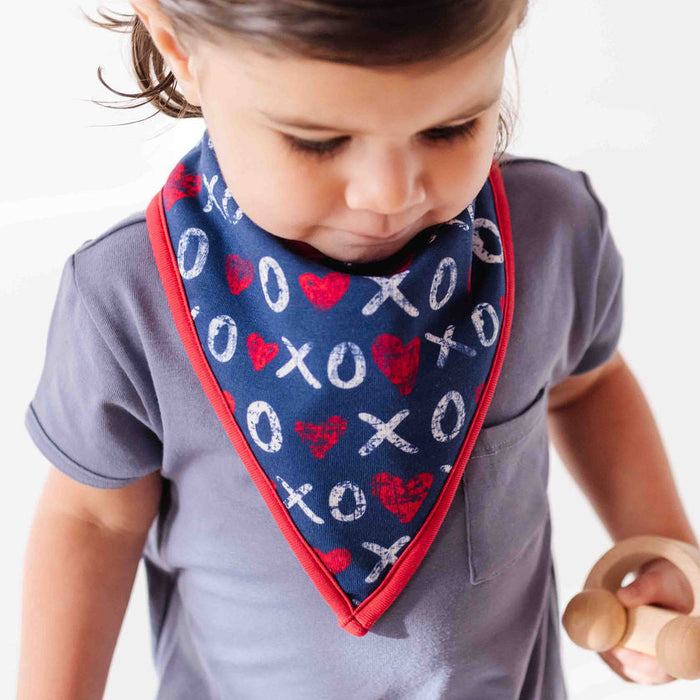 Child wearing a blue bandana with red and white patterns on a plain background